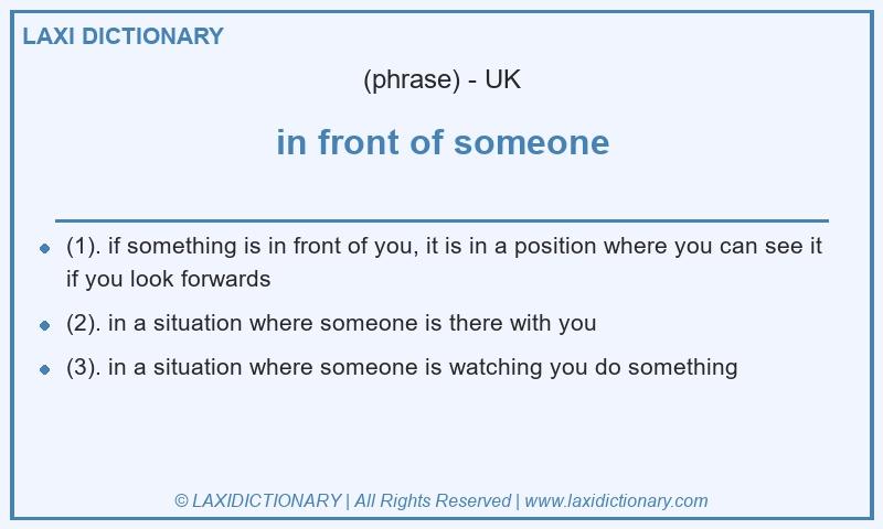 Definition in front of someone in British English